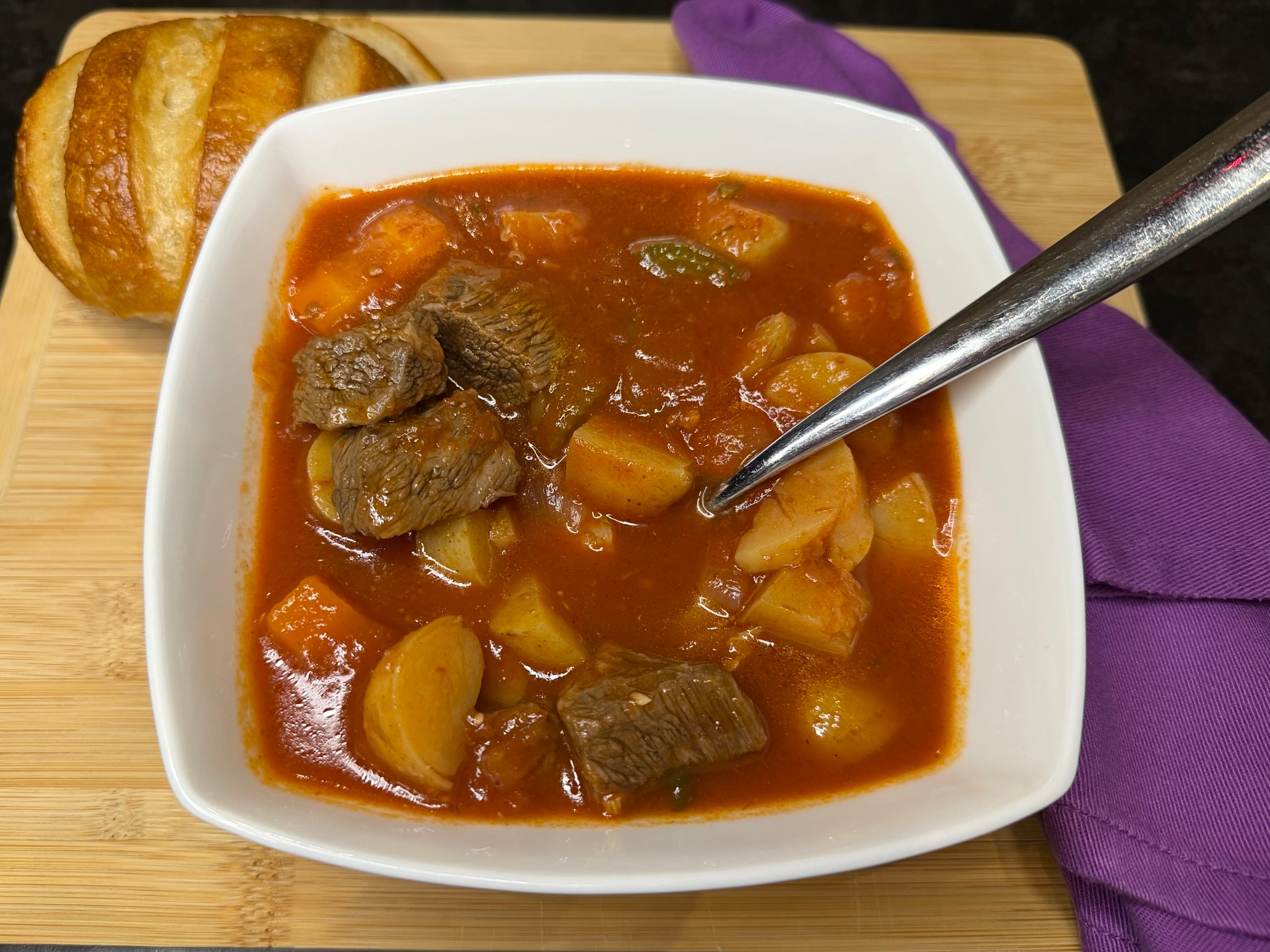 White bowl of beef goulash soup